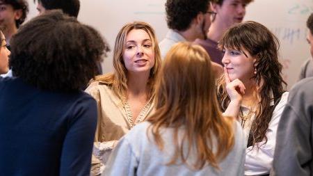 Two band members speaking to a group of students